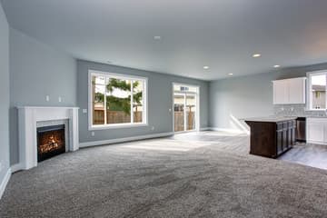 An empty carpeted living room ready for moving in or moving out.